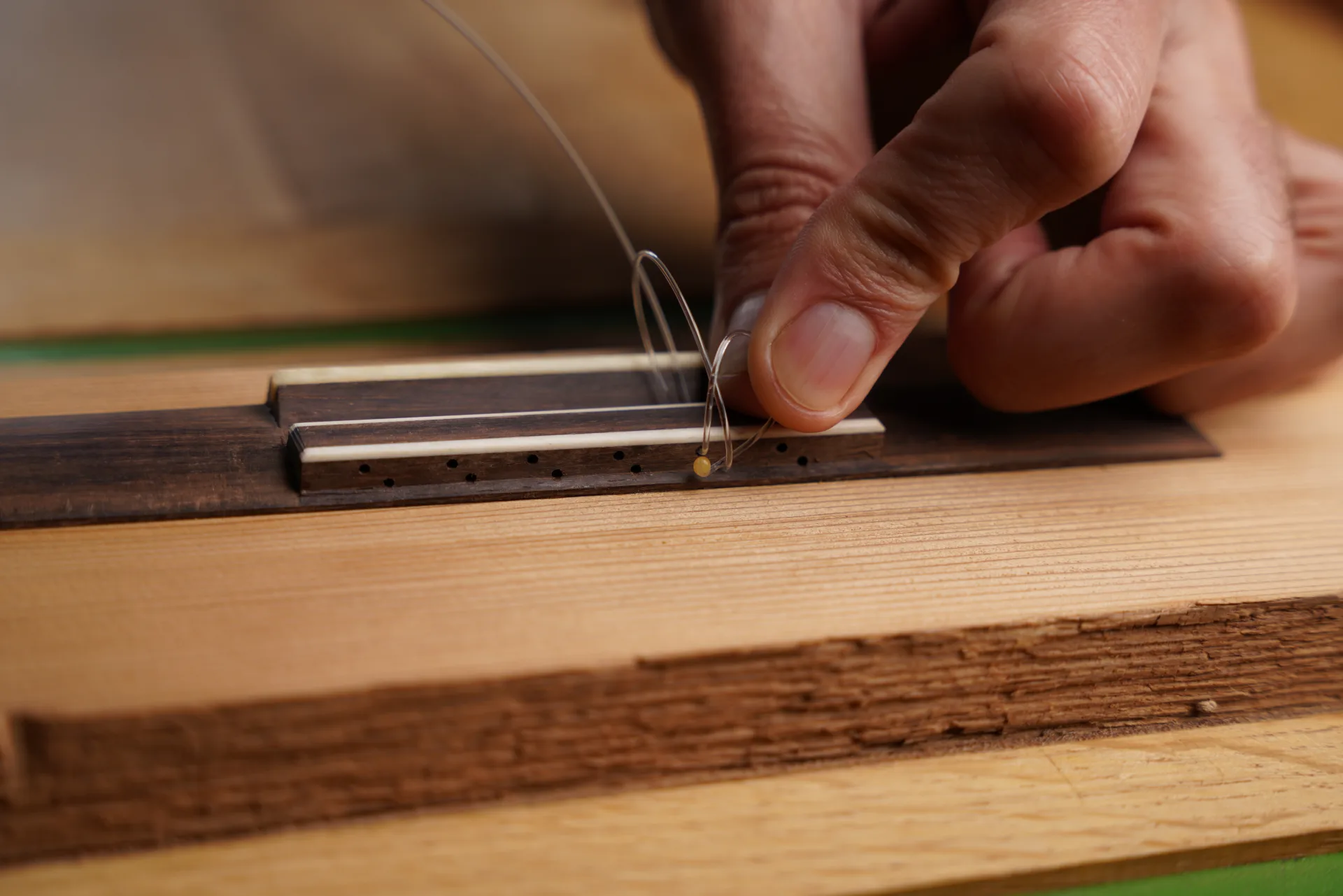 A secure way of tying the treble string on a 12-hole bridge
