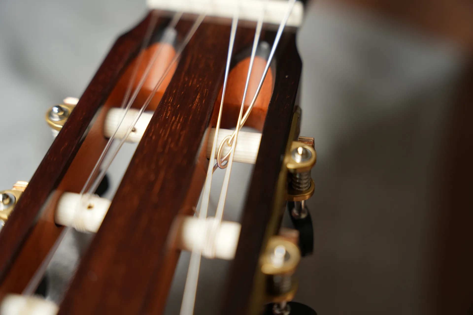 Create a locking loop around the tuning post before winding