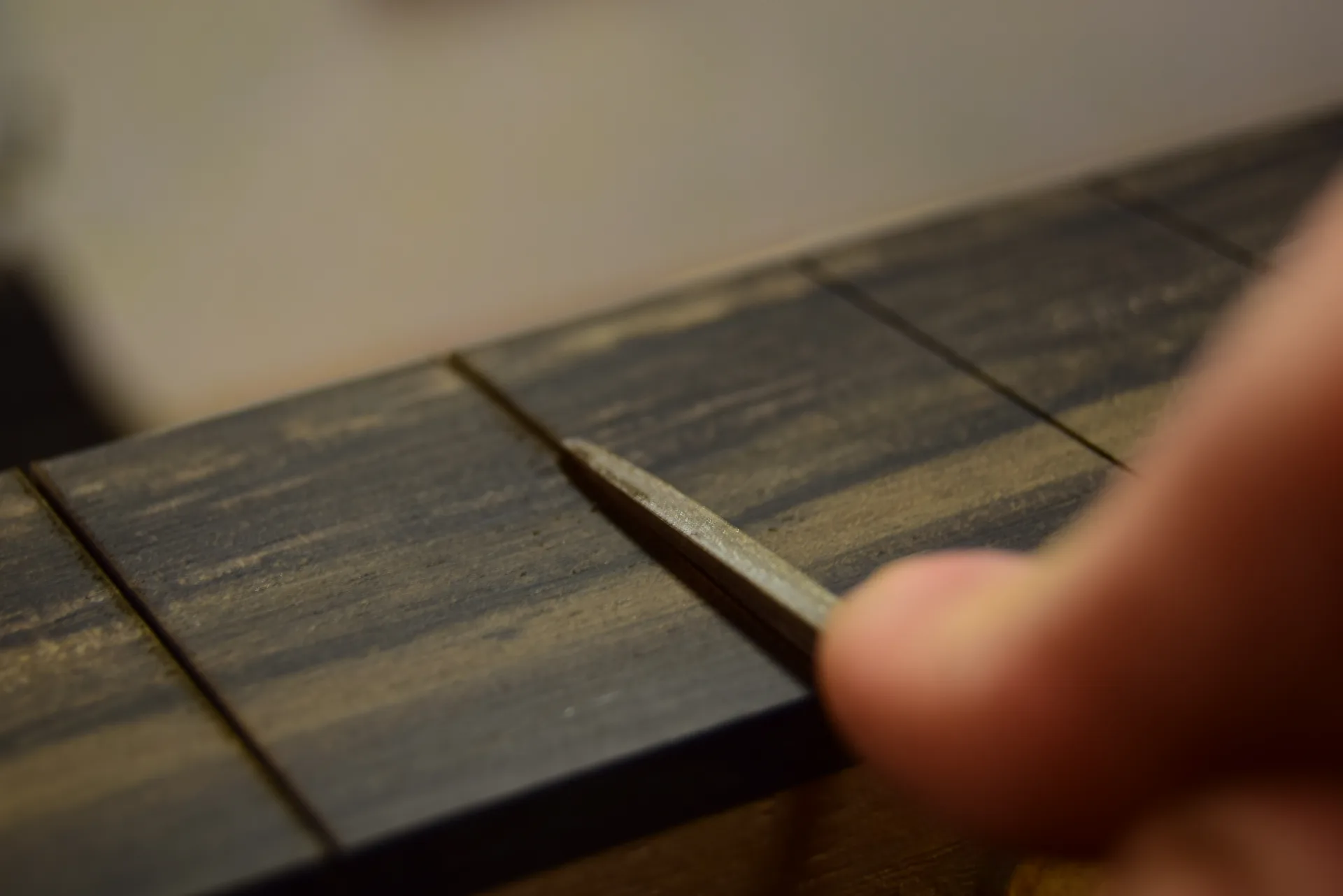 A small chamfer filed into slot edges with a triangular file to prevent tear-out during future refretting