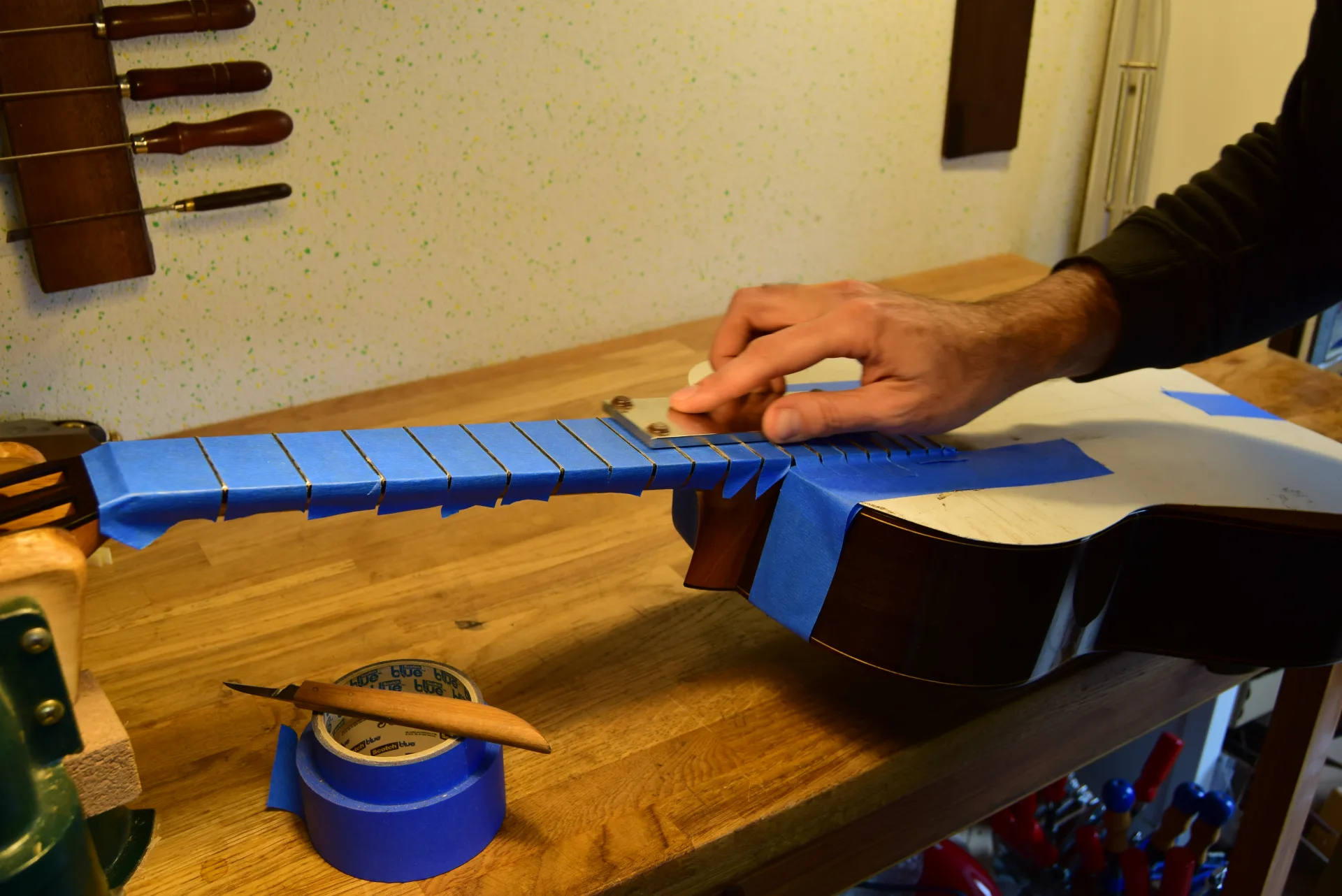 Diamond leveling stone bringing all frets to the same height — material removed gradually along the full length