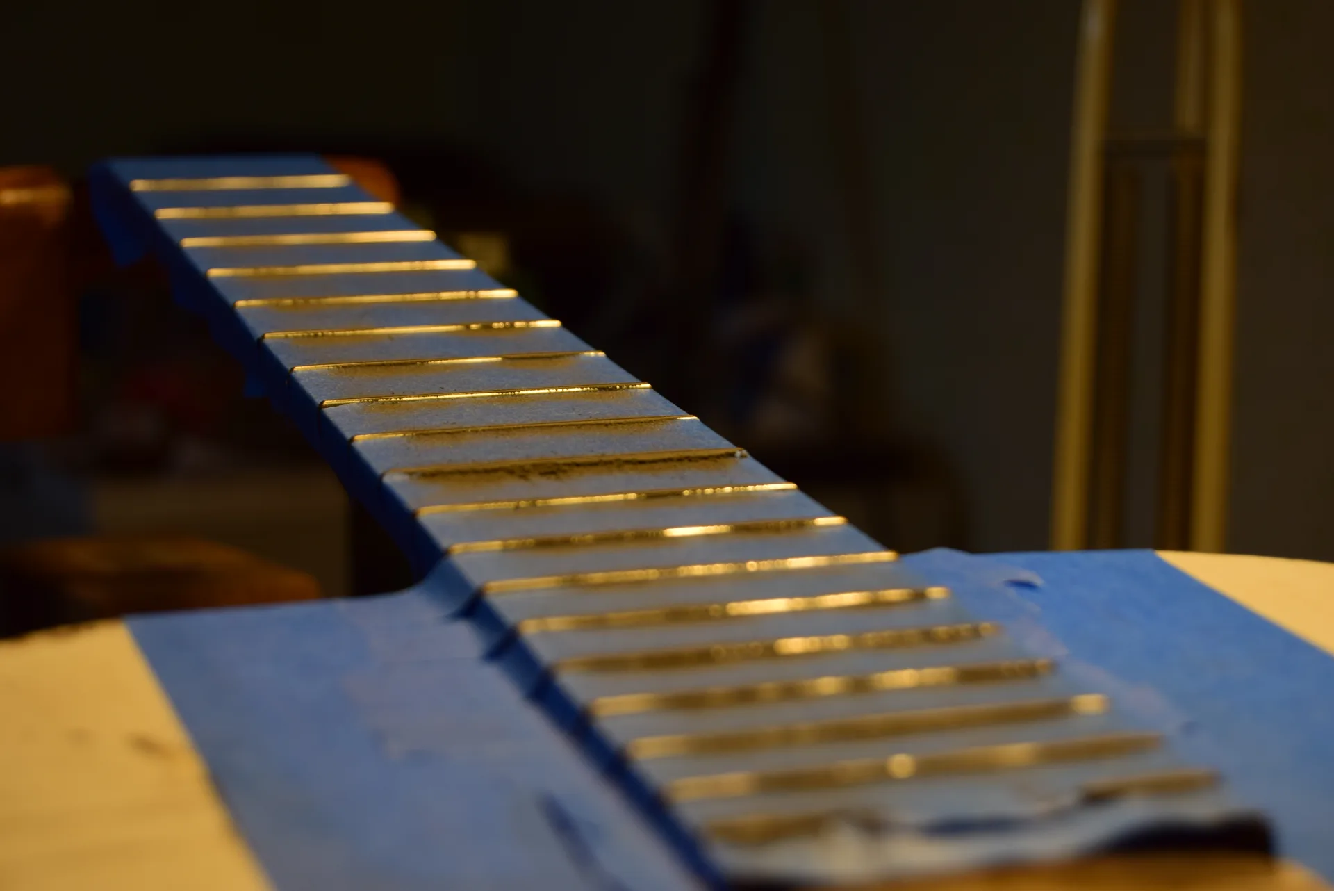 Final leveling in progress — all frets must be perfectly level before crowning