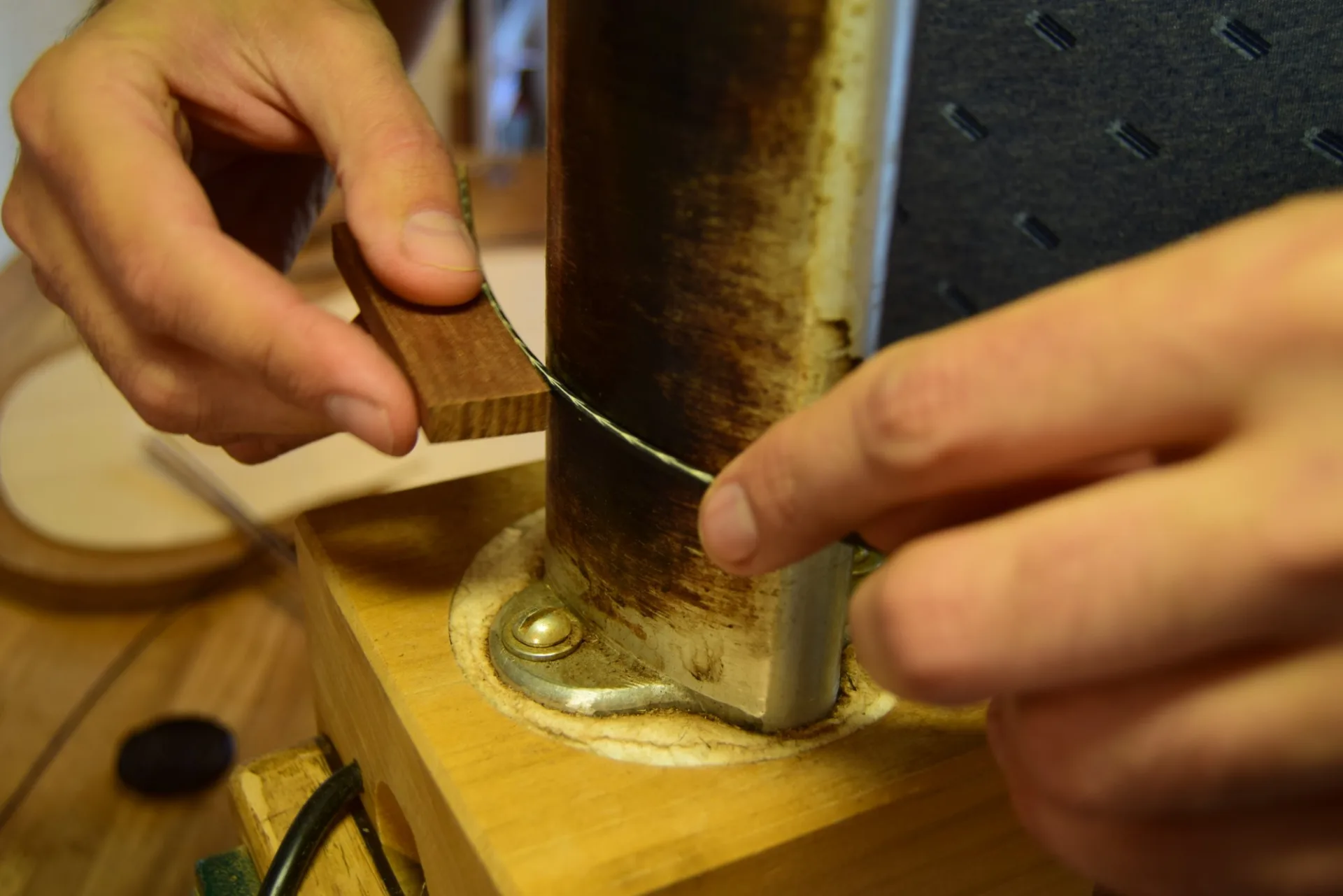Bending the finished motif with heat to prepare it for inlay into the curved rosette channel — moisture would cause it to come apart